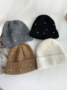 Detail view of soft winter knitted beanies featuring elegant pearl decorations in four colors.