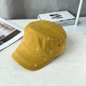 Detailed view of a mustard yellow distressed flat top military cadet cap for fashion