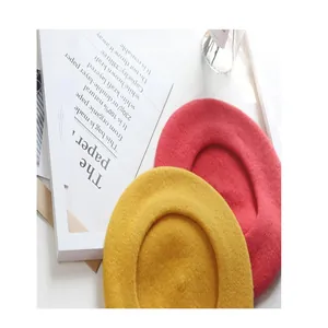 Detailed view of red and yellow wool berets with cozy felt texture for winter.
