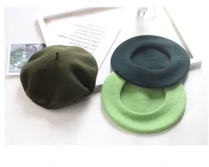 Selection of wool berets in olive and lime green shades for cozy winter fashion styling