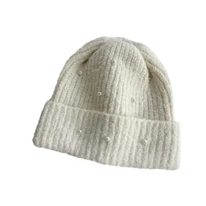 Warm beige knitted beanie hat decorated with elegant white pearls for cold winter days