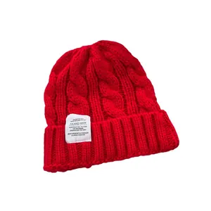 Classico berretto in maglia a trecce rosso con elegante etichetta bianca per l'inverno