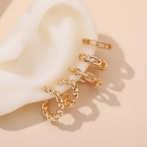 Close-up of golden vintage French style twist and chain link hoop earrings on ear model