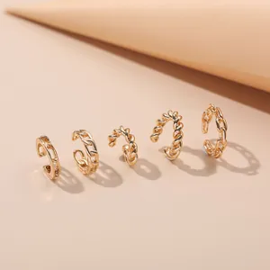 Detailed shot of five gold-toned alloy ear cuffs with twisted and chain link designs
