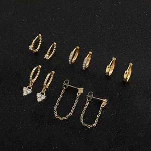 Colección de aretes chapados en oro con cristales de circón sobre un fondo negro elegante