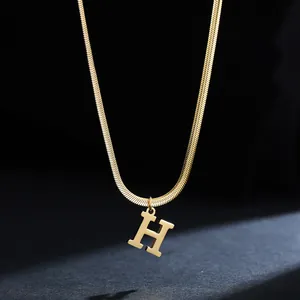 Macro view of gold 18K plated stainless steel snake chain featuring a letter H pendant