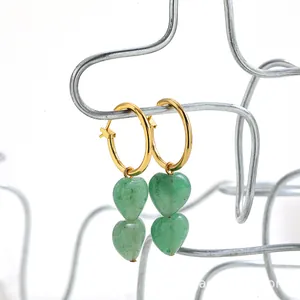 Close-up of French vintage hoop earrings with green heart-shaped stone pendants