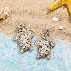 Detailed view of creative handmade beaded turtle earrings featuring sparkling rhinestone shell accents