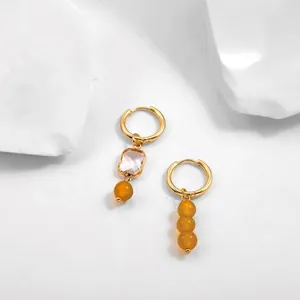 Close-up of French vintage asymmetric stainless steel hoop earrings with yellow beads