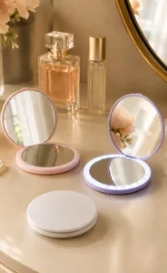 Portable LED folding makeup mirror with illuminated ring light in soft vanity setting