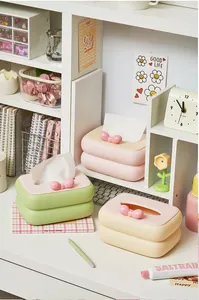 Detailansicht der niedlichen Schleife-Taschentuchboxen im Cream-Stil auf dem Schreibtisch
