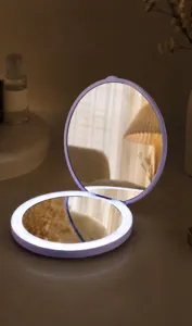Close-up detail of a portable foldable purple LED makeup mirror with bright ring light