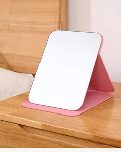 Tragbarer rosa PU-Leder Klapp-Schminkspiegel auf Holzschreibtisch