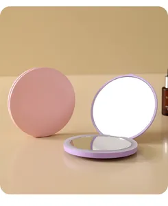 Nahaufnahme von tragbaren runden LED-Make-up-Spiegeln in Pastellrosa und Violett