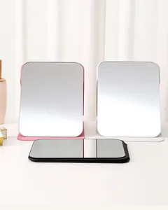 Drei faltbare PU-Leder-Kosmetikspiegel in elegantem Rosa, Weiß und Schwarz auf dem Tisch.