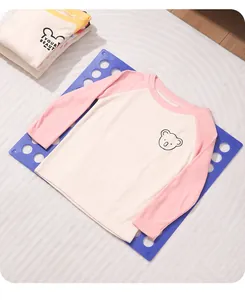 Lila Faltbrett für Kinderkleidung zeigt die praktische Verwendung mit einem T-Shirt