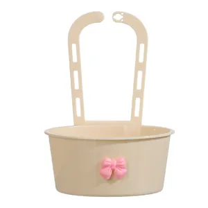 Panier d'égouttage de cuisine beige suspendu avec un joli nœud rose pour l'évier