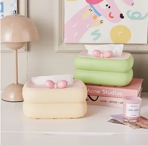 Süße cremefarbene Taschentuchbox mit rosa Schleife auf einem modernen Schminktisch