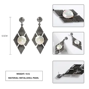 Vista macro di orecchini metallici a rombo con perla di conchiglia e dimensioni.