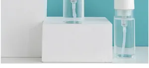 Transparente Schaumpumpflaschen für Gesichtsreiniger auf minimalistischen Blöcken.