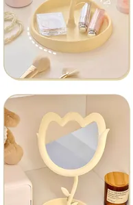Detalle de un espejo de maquillaje con forma de tulipán crema y bandeja a juego
