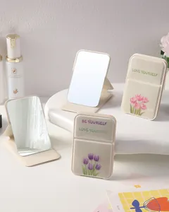 Close-up view of portable folding mirrors with aesthetic tulip prints and slogans