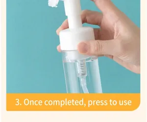 Close-up detail showing how to use the foaming pump bottle dispenser by pressing the head.