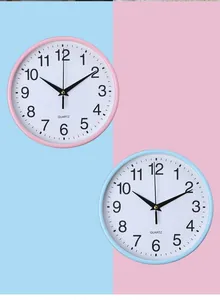 Detailansicht minimalistischer runder Wanduhren in Pastellrosa und hellem Blau.