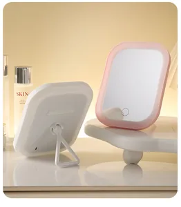 Tragbarer rosa LED-Schminkspiegel mit klappbarem Ständer auf dem Schminktisch