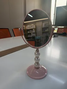 Eleganter rosa Schminkspiegel mit dekorativem Perlenständer für den Schreibtisch.