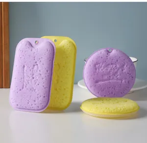 Macro detail view showing texture of purple and yellow wood pulp cotton cleaning sponges