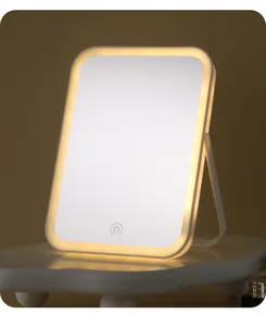 Elegant desktop LED makeup mirror detail showing warm yellow light glow on white stand