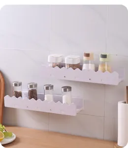 White wall-mounted shelves with decorative wavy edge design shown as kitchen spice racks