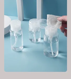 Detail view of a clear plastic travel press pump bottle being used with a cotton pad.