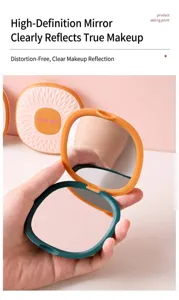 Detail view of a portable square folding makeup mirror held in hand showing double mirrors