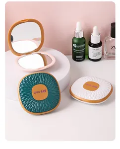 Detailed macro view of the portable folding makeup mirror with magnifying lens feature