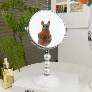Eleganter doppelseitiger Tischschminkspiegel mit Perlensäule und weißem Sockel.
