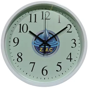 Nahaufnahme einer runden Wanduhr in Hellgrün mit schwarzen arabischen Ziffern.