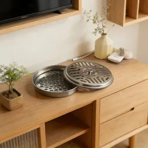 Roestvrijstalen muggenspoelhouder met geometrisch deksel op een houten kast
