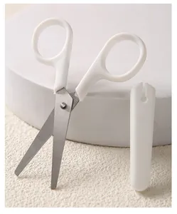 Detail von weißen minimalistischen Scheren mit Sicherheitshülle auf weißem Grund