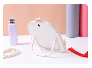 Rückansicht eines weißen Make-up-Spiegels aus Kunststoff mit klappbarem Ständer und Haken