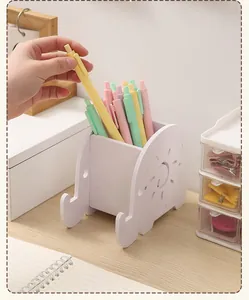 Simpatico portapenne in legno a forma di elefante bianco con delle penne colorate.