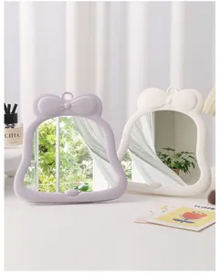 Two cute bowknot desktop makeup mirrors in lavender and cream white for dorm decor.