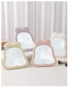 Collection of cute bow-shaped desktop makeup mirrors in various pastel shades for vanity use