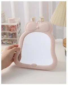 Close-up detail showing the cute pink bow design of this portable desk makeup mirror
