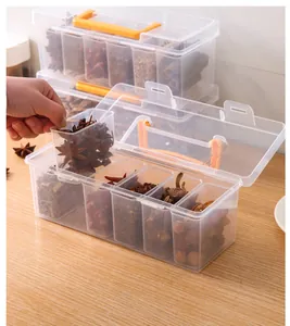 Detail view of transparent spice storage box showing removable compartment and orange handle