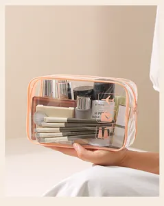 Borsa trucco in PVC trasparente con bordo color pesca e pennelli organizzati