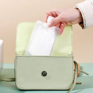 Transparent travel squeeze pouch for lotion storage being placed into a small green bag