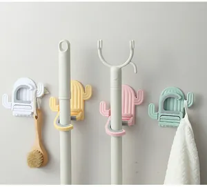 Detail view of cactus-shaped mop holders mounted on a wall with cleaning tools