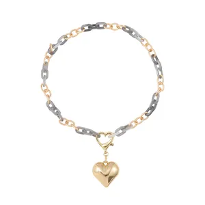 Detail shot of gold heart pendant with mixed gray resin and gold-tone chain links.